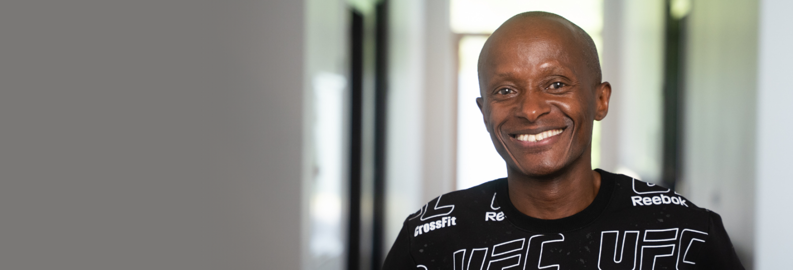 Mandlig medarbejder, der smiler og kigger ind i kameraret